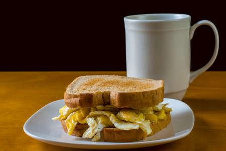 scramble egg  on a toasted wheat bread served with coffeeの写真素材