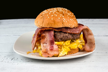 hamburger top served with scramble egg and bacon  on a bunの写真素材