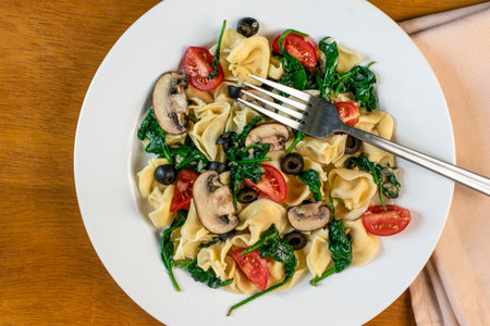 tortellini salad consisting of  mushrooms, olives spinach and tomatoes,の写真素材