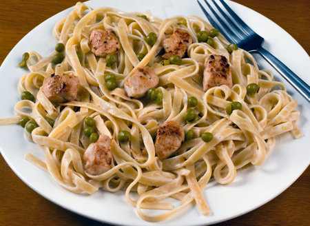 fettuccine top with chicken  and peas  served with alfredo sauceの写真素材