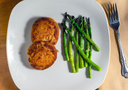 salmon cakes served with sauteed aspargus,の写真素材