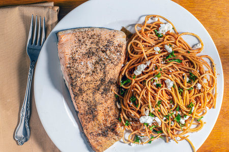 season baked salmon served with wheat wheat spaghetti top with parsley and goat cheese,の写真素材