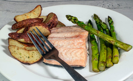 baked salmon served with asparagus and wedges,の写真素材