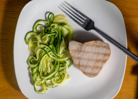 tasty tuna steak served with  zucchini noodlesの写真素材