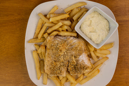 baked haddock  served with a side of fries and tarter sauceの写真素材