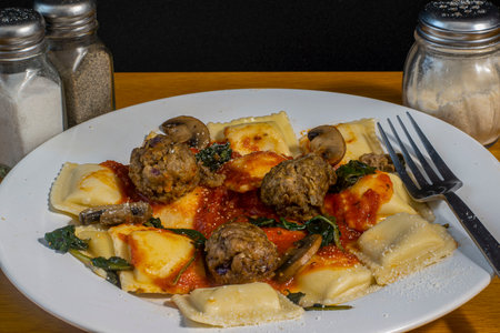 cheese ravioli served with sauteed spinach and  mushrooms,  with meatballsの写真素材