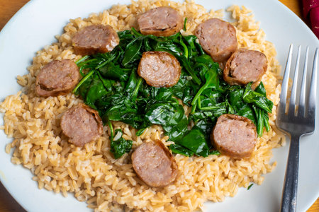 brown rice  served sauteed spinach and italian sausageの写真素材