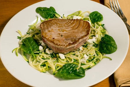 tuna steak  served on top of zucchini noodles with cheese and spinachの写真素材