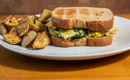 scramble egg  and spinach sandwich  served with season  home fries