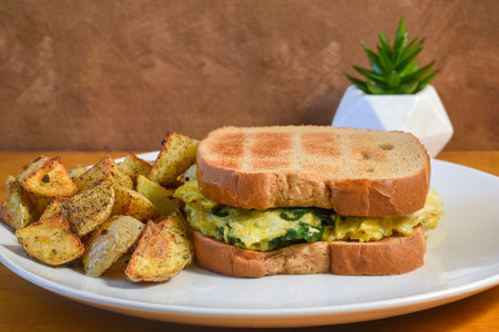 <p>scramble egg and spinach sandwich served with season home fries</p>の写真素材
