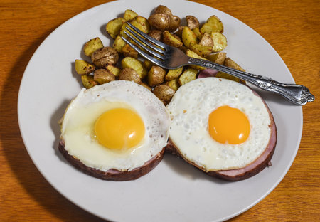 two fried eggs on a   ham  served with home friesの写真素材