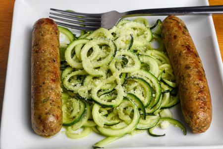 zucchini noodles top with  parmesan cheese,  served with plant based sausage,の写真素材