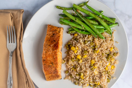 baked salmon served with  brown rice  top with corn and peasの写真素材