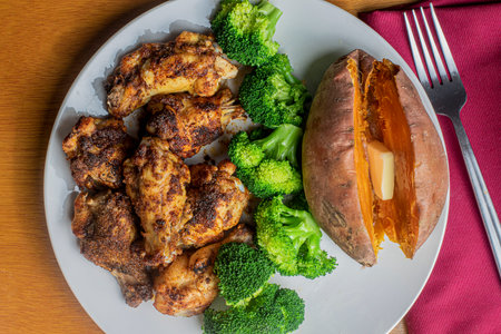 chicken wings served with broccoli and a sweet potato.の写真素材
