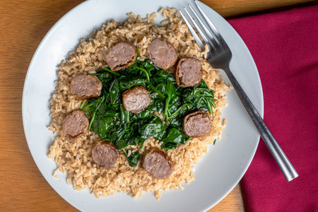 brown rice served with sauteed spinach and  italian sausageの写真素材