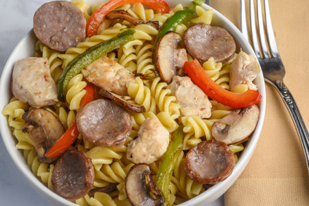 rotini pasta served with chicken , sausages and peppersの写真素材