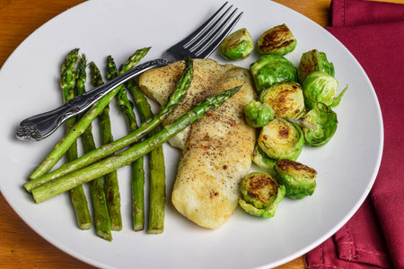 tilapia served with  asparagus and roasted brussel  sprouts.の写真素材