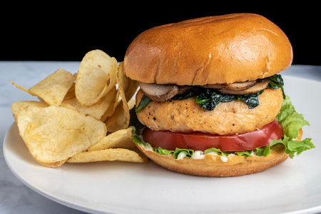 salmon burger top with  sauteed spinach and mushroomsの写真素材