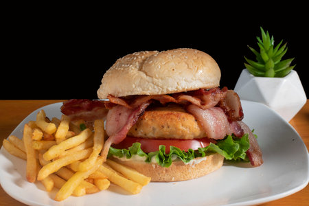 salmon burger with bacon lettuce and tomato served with friesの写真素材