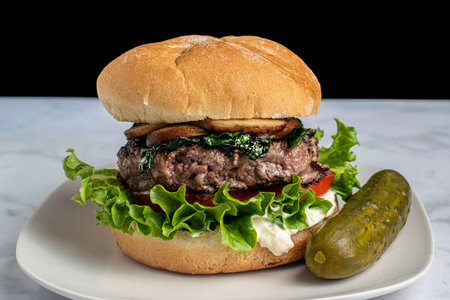 hamburger top with sauteed mushrooms  and spinach  on a bulkie rollの写真素材