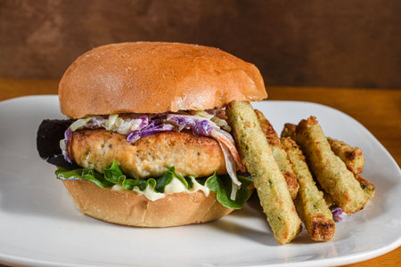 salmon burger top with cole slaw and served with broccoli friesの写真素材