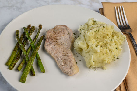 boneless pork chop seasoned with pepper served with asparagus and mashed potatoes,の写真素材
