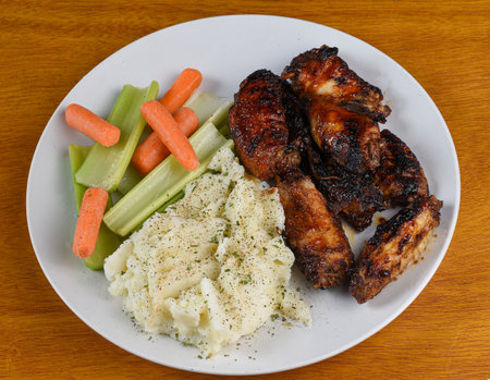 barbecue chicken wings served  with celery and carrotsの写真素材