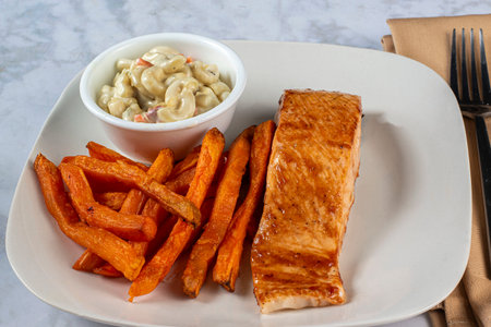 baked barbecue salmon served with  macaroni slad and sweet potato fries,の写真素材