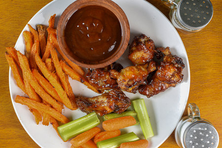 bufflo wings with carrots, celery and sweet potato fries,の写真素材