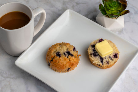 blue berry muffin top with butter aerved with fresh coffeeの写真素材