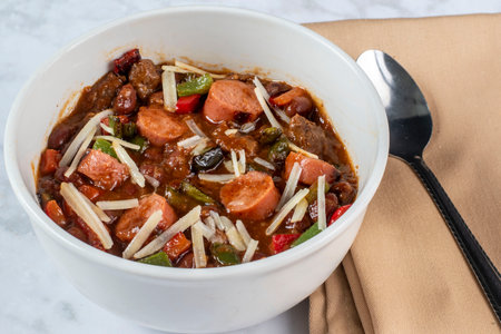 bowl of chil served with   hot dogs  pepers and shredded parmesan cheese,.の写真素材