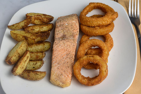 baked salmon season with pepper  garlic salt  served  with onion rings and garlic saltの写真素材