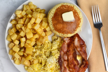 scramble  eggs  and pancakes served with hash browns and baconの写真素材