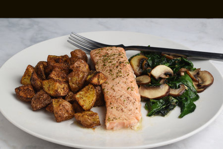 baked season salmon served with sauteed spinach and mushroomsの写真素材