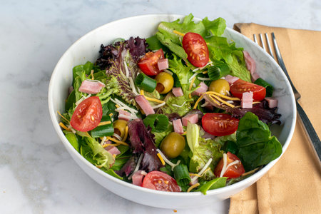 salad   top with ham and cheese and served with tomatoes and olivesの写真素材
