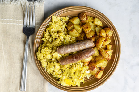 scramble eggs served with home fries and top with breakfast sausage,の写真素材