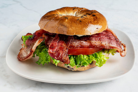 bacon lettuce and tomato served on a blue beery bagelの写真素材