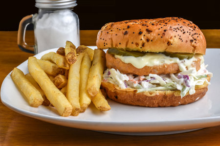 salmon burger on cole slaw  top with tarter sauce  and pickles on a brioche bunの写真素材