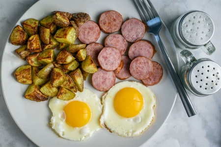 fried eggs served with kielbasa with home friesの写真素材