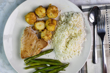 tuna steak served with scallops  with a side of rice and green beans