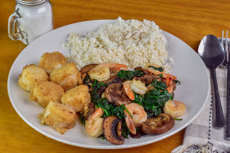scallops with sauteed shrimp spinach and mushrooms served with riceの写真素材