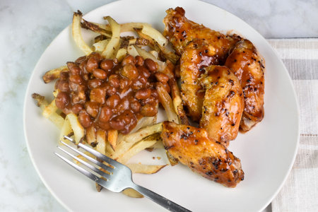 chicken wings top with barbecue  sauce  served with chili friesの写真素材