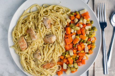 chicken alfredo served with  a side of mixed  vegetables.の写真素材