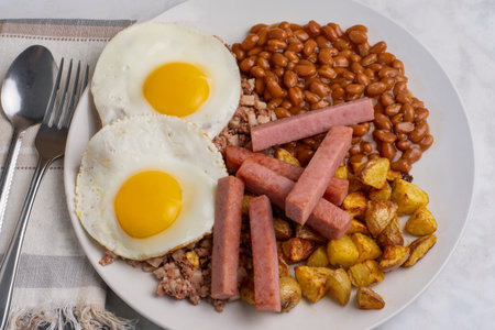 fried eggs with corn beef hash , baked beans and home fries served with  spam fries
