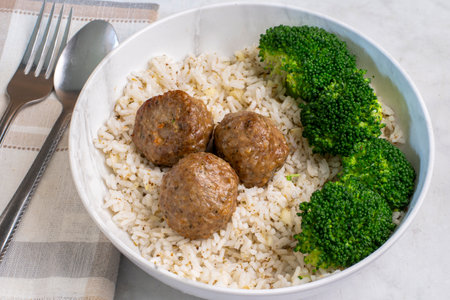 three  italian style meat balls served with  broccoli and riceの写真素材