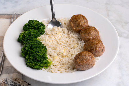 white rice  and broccoli served with  italian style meat balls