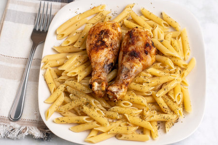 chicken drumsticks served on penne  pasta top with herbsの写真素材