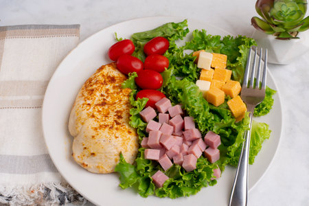 seasoned chicken breast  served with lettuce, tomato, ham and cheeseの写真素材