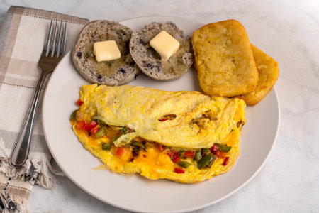 eppers and onions omelette  with hash browns and english muffinsの写真素材