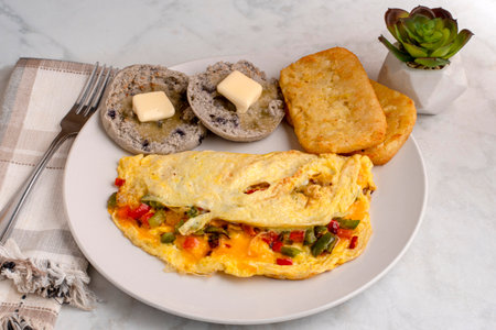 eppers and onions omelette  with hash browns and english muffinsの写真素材